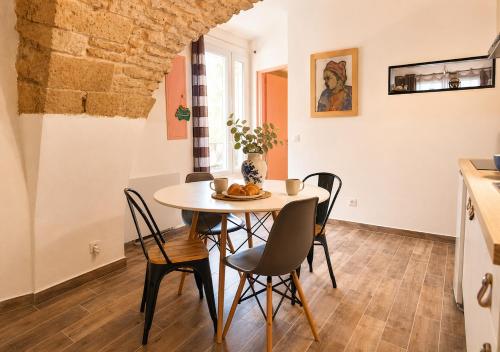 a kitchen and dining room with a table and chairs at L'écrin du Pont du Gard - Parking gratuit - Charme & Pierres in Remoulins