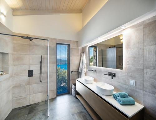a bathroom with two sinks and a shower at Grey Sea View Estate - Luxury Villas with Private Pool & Plunge Pool in Katouna