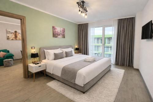 a bedroom with a large bed and a large window at Alezzi Beach Resort - Sea View Suite in Mamaia Sat/Năvodari