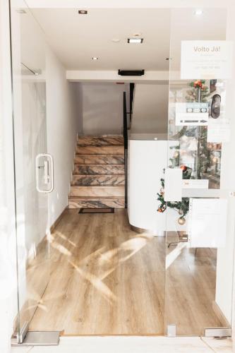 a room with a glass door and wooden floors at Anoitecer Itinerante AL - Vintage Bedrooms by Lethes Legacy in Ponte de Lima