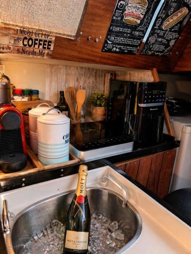 a bottle of champagne in a kitchen sink at Nuit Insolite à bord d'un Voilier Sète Vieux Port in Sète