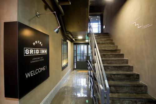 a staircase in a building with a welcome sign on the wall at Grid Inn Hotel in Seoul