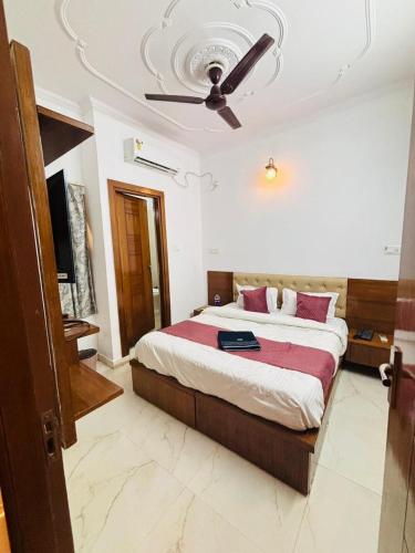 a bedroom with a bed with a ceiling fan at Hotel King's Residency in Narendranagar