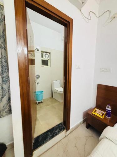 a bathroom with a mirror and a toilet in a room at Hotel King's Residency in Narendranagar