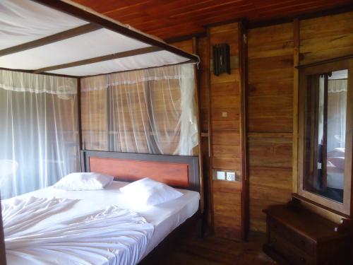 a bedroom with a bed and a tv in it at Eco Cabanas Marakolliya in Tangalle