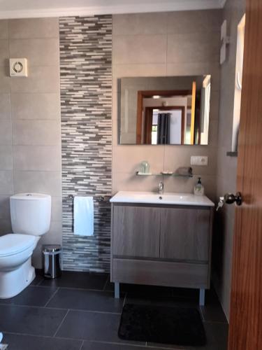 a bathroom with a sink and a toilet at Casinhas in Praia do Almoxarife