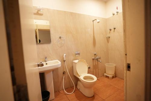 a bathroom with a toilet and a sink and a shower at JK Golden Embassy in Mysore
