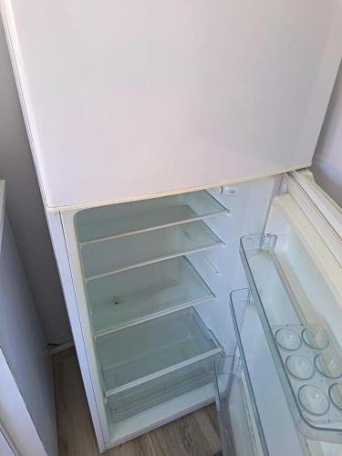 an empty refrigerator with its door open at Piso Buenos Aires in Cee