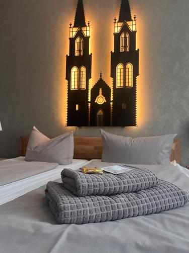 a bedroom with a bed with a clock on it at Pension am Park in Oschatz