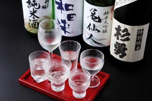 a red tray with four wine glasses on a table at Tsukasaya Ryokan in Tsuruoka