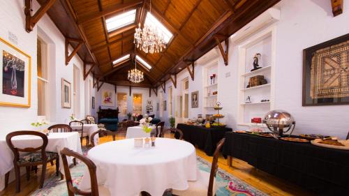 a dining room with tables and chairs and a chandelier at Arcoona Manor in Deloraine