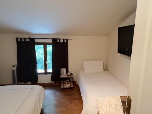 a small room with two beds and a window at 43 Rue des Quarts in Ménesplet