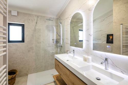 a white bathroom with a sink and a shower at CASA LEONE - fully renovated since April 2026 - new pictures in Carvoeiro