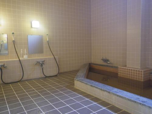 a bathroom with a bath tub and a sink at Resort Inn Murata in Iiyama