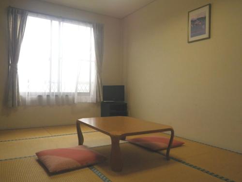 a living room with a coffee table and a window at Resort Inn Murata in Iiyama