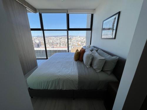 a bedroom with a bed with a view of a city at MOTTO Executive Stays Condominium in Hércules