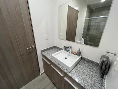a bathroom with a sink and a mirror at MOTTO Executive Stays Condominium in Hércules