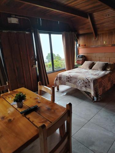 a bedroom with a bed and a table and a table sidx sidx sidx at Reserva Natural Cerro Alto in Empalme
