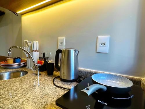 a kitchen counter with a mixer and a sink at Flat Executive City Jardins in São Paulo