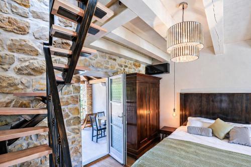 a bedroom with a bed and a stone wall at Deluxe Nature Resort Galovi Dvori in Rab