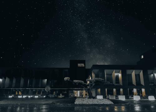 a building with a tree in front of it at night at Alambique - Hotel Resort & Spa in Fundão