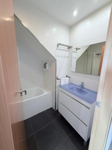 a bathroom with a tub and a sink and a mirror at Iberflat Apartamentos Marina Suites in Grao de Castellón