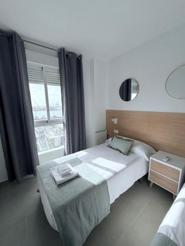 a bedroom with a large bed and a window at Iberflat Apartamentos Marina Suites in Grao de Castellón