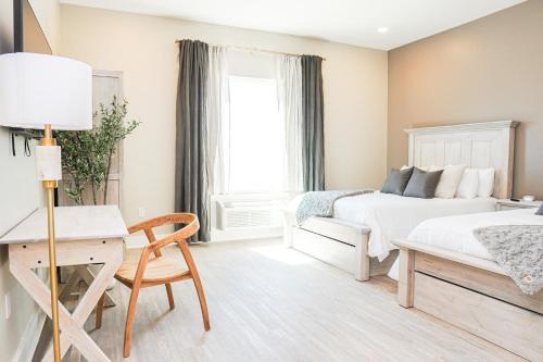 a white bedroom with a bed and a desk at Hotel Whiskey in Long Beach in Long Beach