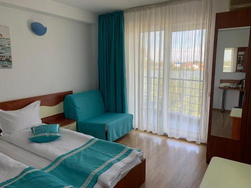 a bedroom with a bed and a chair and a window at Marina House in Sulina