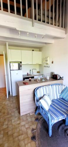 a living room with a couch and a kitchen at Duplex Camargue Village in Le Grau-du-Roi