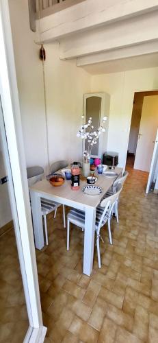 a white dining room table and chairs in a room at Duplex Camargue Village in Le Grau-du-Roi