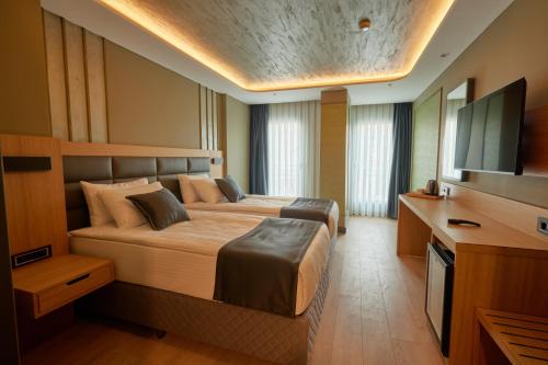 a bedroom with a large bed and a flat screen tv at igman Hotel İstanbul in Istanbul