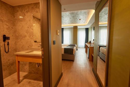 a room with a bathroom with a sink and a bedroom at igman Hotel İstanbul in Istanbul
