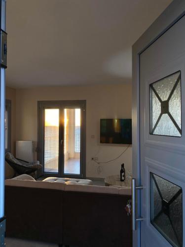 a living room with a door with a view of a room at Athos view house in Agios Ioannis Kaspaka