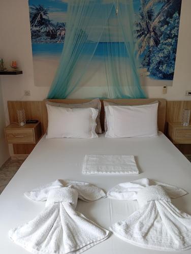 a white bed with two white towels on it at Maria Charalampaki Studios in Skiros