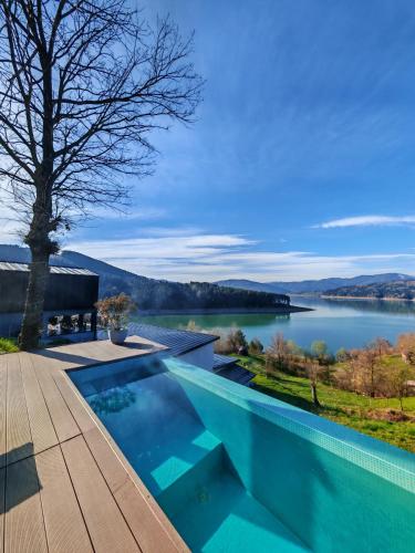 a swimming pool with a view of a lake at Moon Lake Bicaz - Casa Oia in Buhalniţa