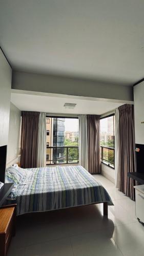 a bedroom with a bed and a large window at Quarto Sol in Brasília