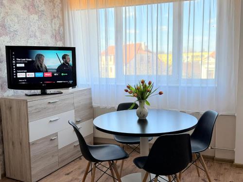 a living room with a table and a tv at Kesk Central Apartment in Valga