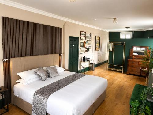 a bedroom with a large bed and a green wall at The Olive in Market Rasen