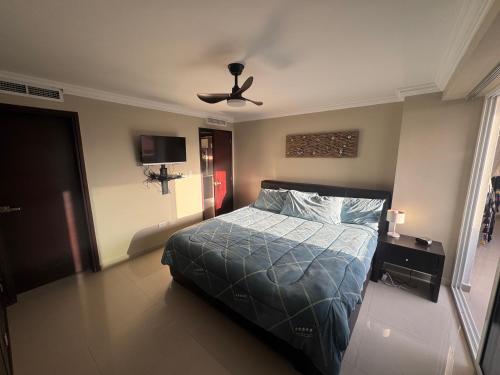 a bedroom with a bed and a ceiling fan at Apartamento Costa Azul Oasis frente CC La Vela in Porlamar