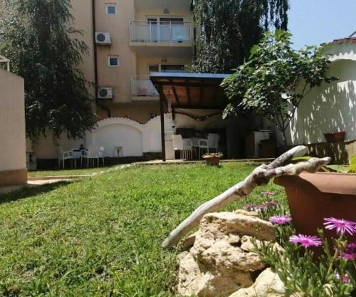 a view of a yard with a building and flowers at Siana House in Ravda