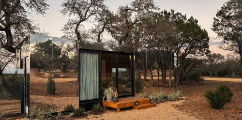 a glass house in the middle of a field at Lagom Retreat in Dripping Springs