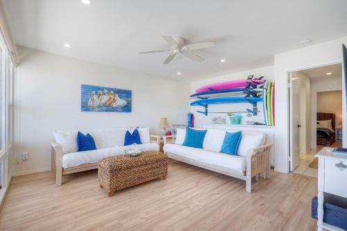 a living room with two white couches and blue pillows at Oceanfront 2BR - Private Patio - Steps to Beach in Carlsbad