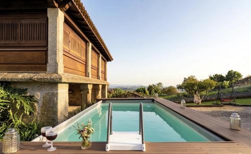 a swimming pool on a deck next to a house at Villa Miranda Heritage House in Creixomil
