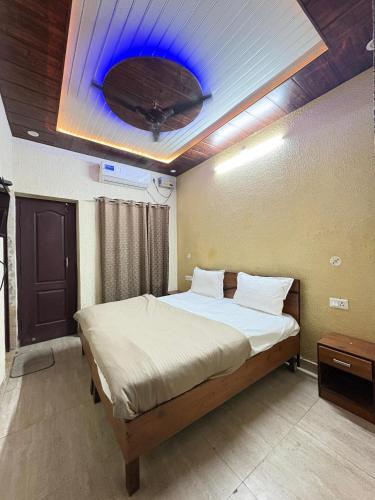 a bedroom with a bed with a blue light on the ceiling at HOTEL O DEV RAJ Homestay in Rishīkesh