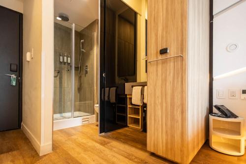 ein Badezimmer mit Dusche und Holztür in der Unterkunft Hotel Nodo - El primer hotel de negocios en Chile in Santiago