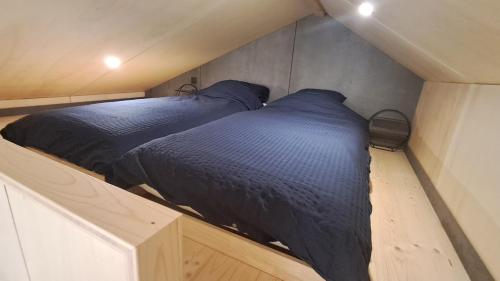 two beds in a small room with blue sheets at Chalet Villerest in Villerest
