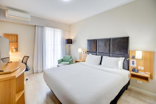 a hotel room with a large bed and a television at Comfort Ibirapuera in São Paulo