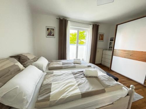 two beds in a bedroom with a large window at Wien an Donau in Vienna