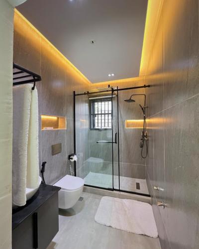 a bathroom with a shower and a toilet and a sink at The Mansion in Abuja